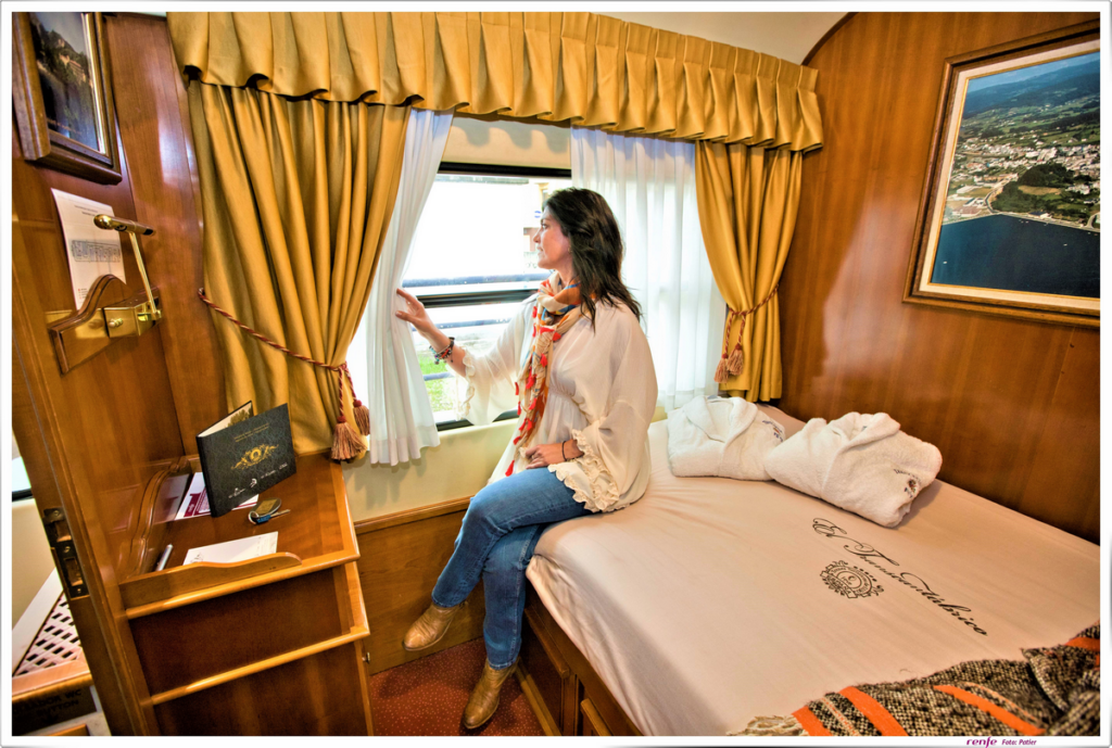 Woman admiring view from Costa Verde Luxury Train cabin in Spain